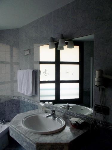 a bathroom with a sink and a window at Hotel Gijon in Gijón