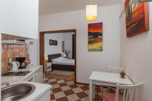 a kitchen with a sink and a bed in a room at Apartments Green Scenic in Dubrovnik