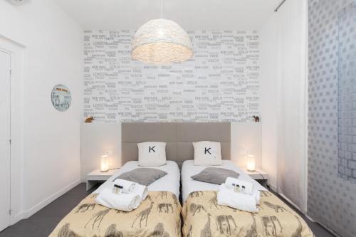 - une chambre avec 2 lits et un grand mur dans l'établissement Voyage 2 pièces 3 étoiles calme plein centre à 5mn des plages et du Palais, à Cannes