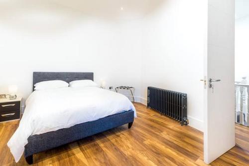 1 dormitorio con 1 cama y suelo de madera en Stunningly Luxurious London Apartment (MHB350) en Londres
