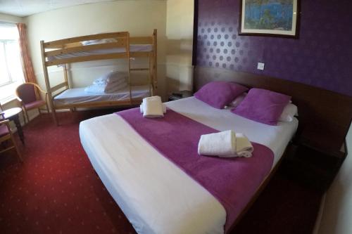 a hotel room with two beds and a bunk bed at The Grand Burstin Hotel in Folkestone