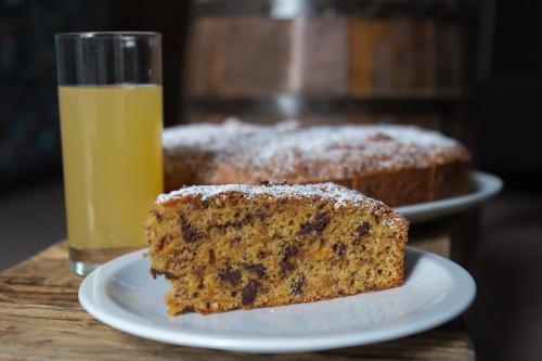 un pezzo di torta su un piatto accanto a un bicchiere di succo d'arancia di Locanda Villa Fiori a Bellaria-Igea Marina