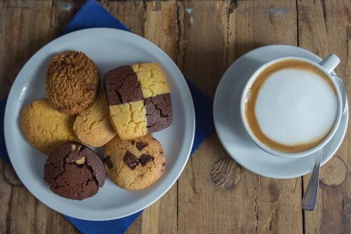 un piatto di biscotti e una tazza di caffè di Locanda Villa Fiori a Bellaria-Igea Marina