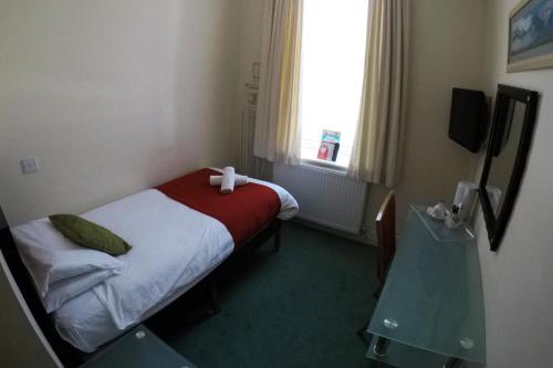 a hotel room with a bed with a red blanket at The Grand Burstin Hotel in Folkestone
