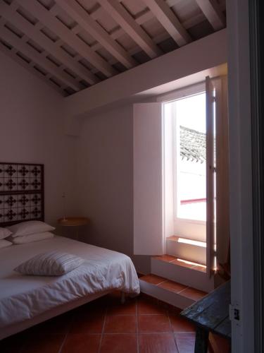 メディナ・シドニアにあるApartamentos La Lobaのベッドルーム(ベッド1台、窓付)