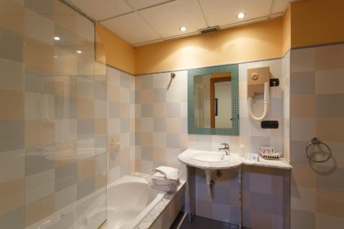 a bathroom with a tub and a sink and a shower at Hotel Restaurante Pontiñas in Lalín
