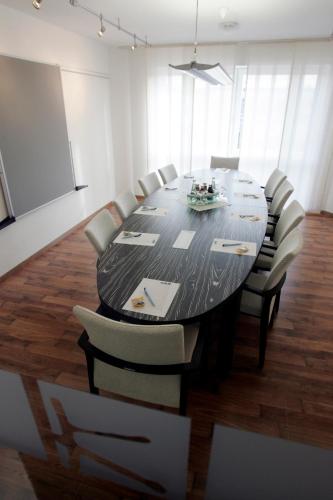 a conference room with a black table and chairs at Hotel im Kornspeicher in Marburg an der Lahn
