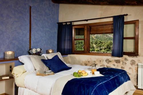Apartamentos Can Juver في بيسييت: غرفة نوم بها سرير مع صينية من الفواكه عليها