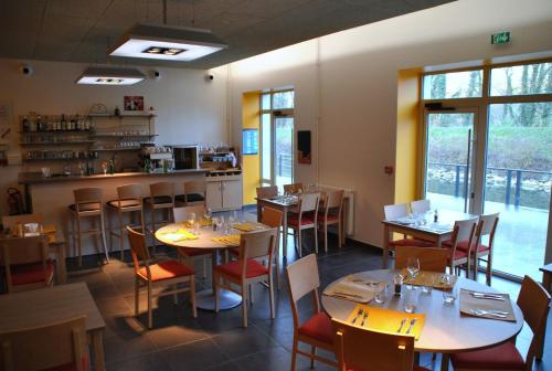 ボーム・レ・ダムにあるULVF Le Domaine d'Aucroixのテーブルと椅子のあるレストラン、キッチンが備わります。