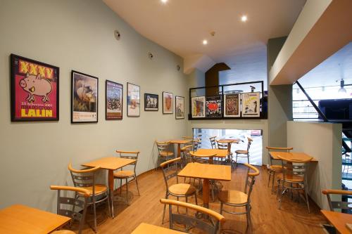 a restaurant with wooden tables and chairs and pictures on the wall at Hotel Restaurante Pontiñas in Lalín