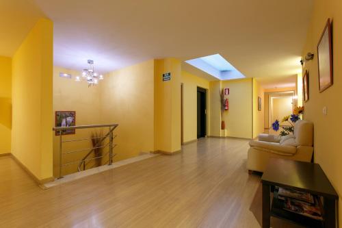a living room with yellow walls and a couch at Hotel Restaurante Pontiñas in Lalín