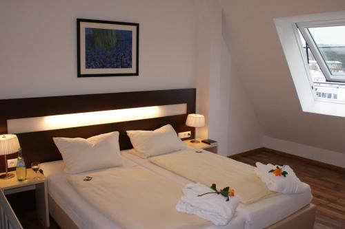 a bedroom with a large white bed with towels on it at Hotel im Kornspeicher in Marburg an der Lahn