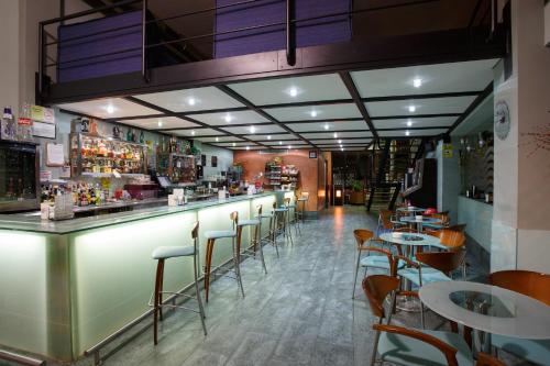 a restaurant with a bar with chairs and tables at Hotel Restaurante Pontiñas in Lalín