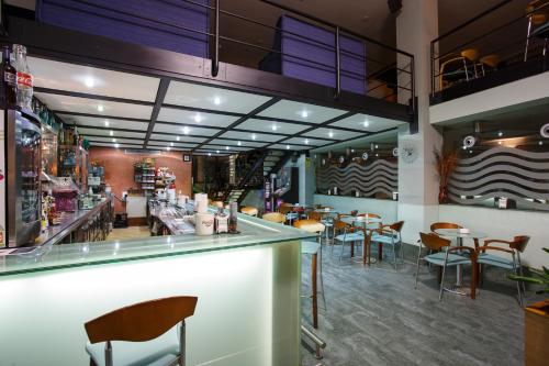 a restaurant with a bar and tables and chairs at Hotel Restaurante Pontiñas in Lalín