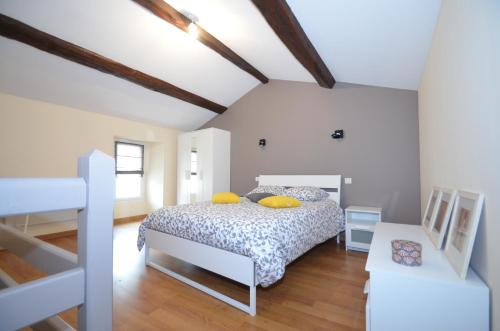 una camera da letto con letto e cuscini gialli di Les Pénates a Saint-Laurent-sur-Sèvre