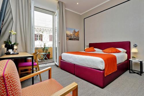 een hotelkamer met een groot bed met een oranje deken bij Relais Vittoria Colonna in Rome