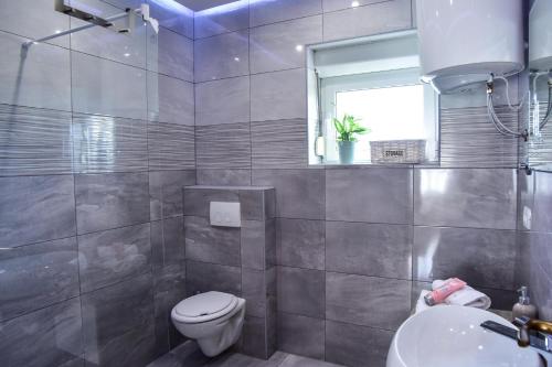 łazienka z toaletą, umywalką i oknem w obiekcie Villa Rubesco w mieście Sikovo