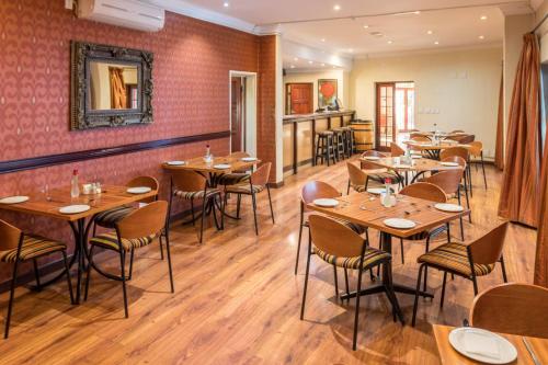 a dining room with wooden tables and chairs at Constantia Hotel and Conference Centre in Midrand