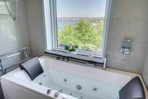 uma grande banheira branca na casa de banho com uma janela em Fjordhuset em Broager