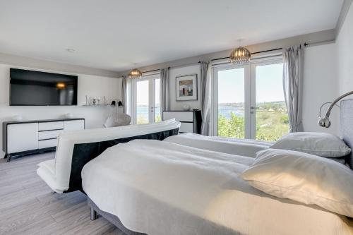 a bedroom with two beds and a large window at Fjordhuset in Broager