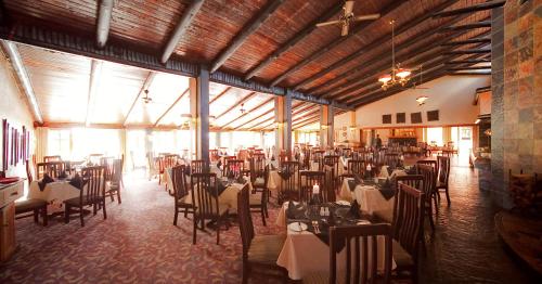 a dining room with tables and chairs in a building at African Sky Hotels - Pine Lake Inn in White River