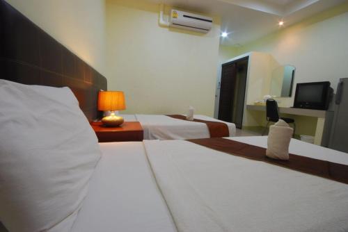 a hotel room with two beds and a television at Buathong Place in Lamai
