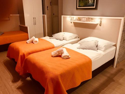 two beds in a hotel room with towels on them at Vila Marija in Skradin