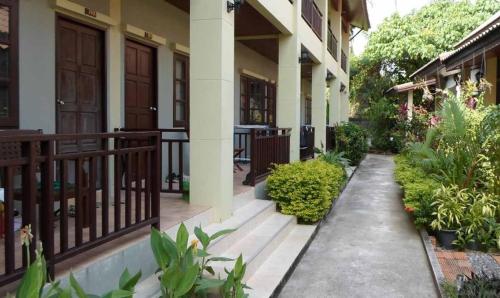 a courtyard of a building with plants and a balcony at Buathong Place in Lamai