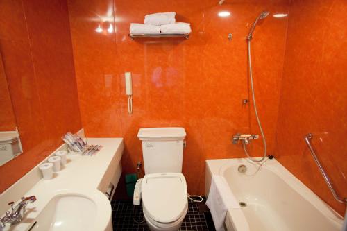 a bathroom with a toilet and a sink and a tub at Hotel Monterey La Soeur Osaka in Osaka