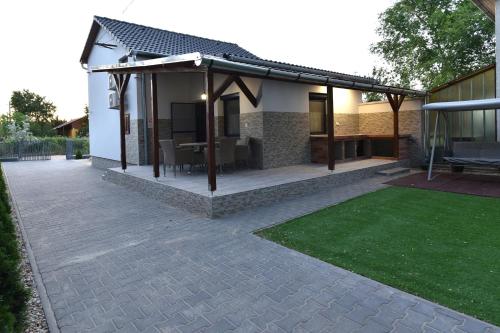 a house with a pavilion with a patio at Sirály Apartman in Hajdúnánás