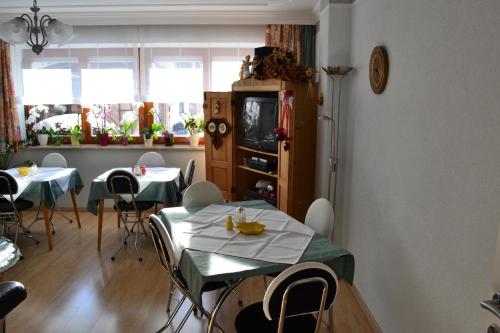 uma sala de jantar com duas mesas e cadeiras e uma televisão em Gästehaus Feistritzer em Malta
