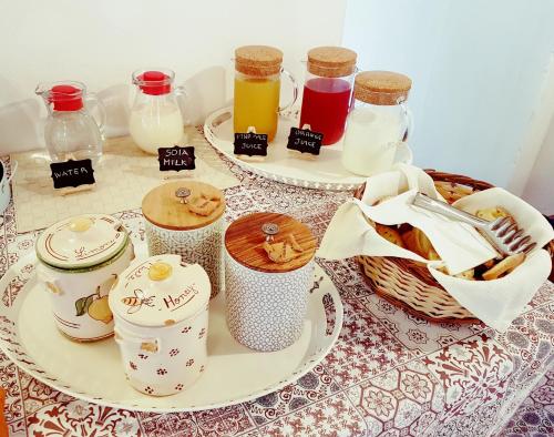 a table with plates of food and jars of milk at Le Case Del Merlo Turismo Rurale in Milo