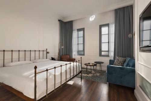 a bedroom with a large bed and a blue couch at Akotika boutique in ‘Akko