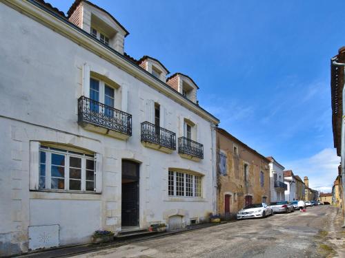 Villefranche-du-PérigordにあるHoliday home near a private gardenのバルコニー付き白い建物、路上駐車車