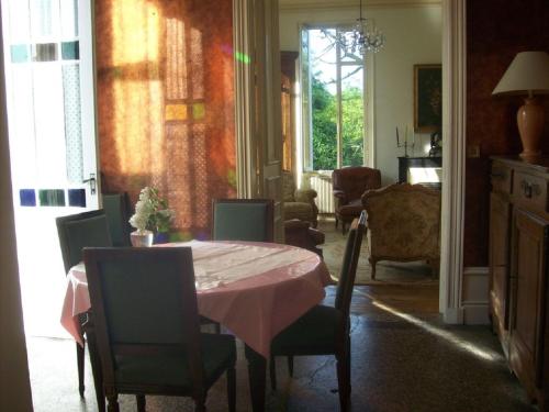 une salle à manger avec une table et un tissu de table rose dans l'établissement Château Fontclaire, à Pons