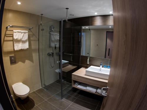 a bathroom with a sink and a shower and a toilet at Thermal Hotel Balance Lenti in Lenti