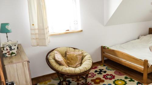 a bedroom with a chair and a bed and a window at Dom w Głuszynie z linią brzegową in Głuszyn
