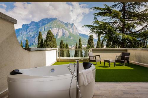 a bath tub on a balcony with a view of a mountain at Hotel Griso Collection in Malgrate