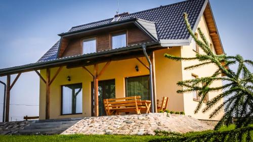 a yellow house with a bench in front of it at Dom w Głuszynie z linią brzegową in Głuszyn