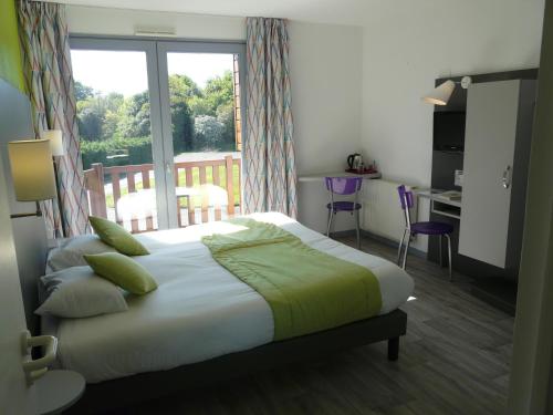 Habitación de hotel con cama y balcón en Hôtel de la baie de Paimpol en Ploubazlanec