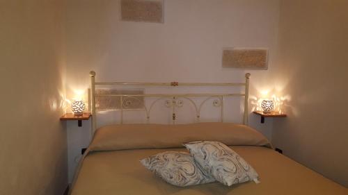 a bedroom with a bed with two lights on it at Torres Suite in Polignano a Mare