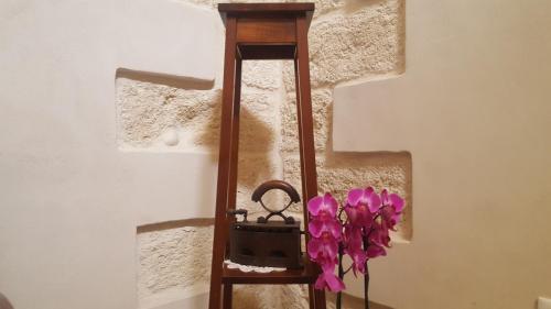 a wooden clock with purple flowers in it at Torres Suite in Polignano a Mare