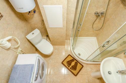 Un baño con ducha, inodoro y lavabo. en ARTAL Apartment on Obolonskyi Avenue 16a, en Kiev