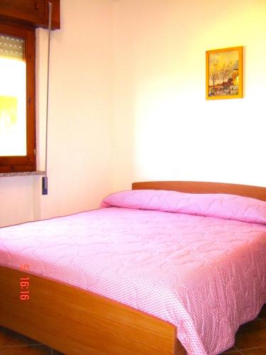 a bedroom with a bed with a purple bedspread at Apartment Valentina in Tergu