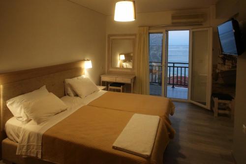 a bedroom with a bed with a view of the ocean at Sappho Plomari in Plomarion