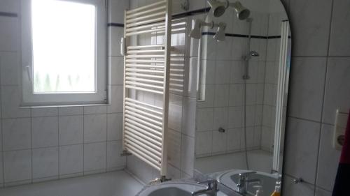 オストゼーバート・ニーンハーゲンにあるOstseeferienwohnung Pascherのバスルーム(洗面台、鏡、窓付)