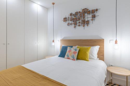 een slaapkamer met een wit bed en een houten hoofdeinde bij Porto Blue Terrace in Porto