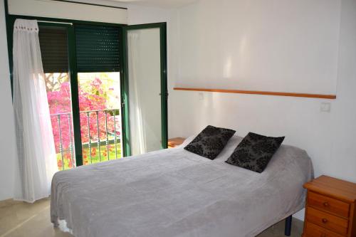 AduanasにあるApartamento Jardines del Marのベッドルーム1室(枕2つ、窓付)