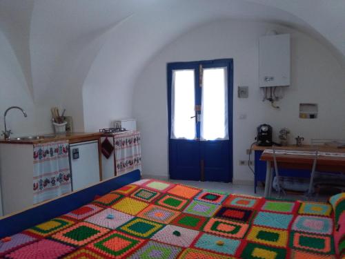 a room with a kitchen with a colorful rug on the floor at Casetta Blu in Tricarico