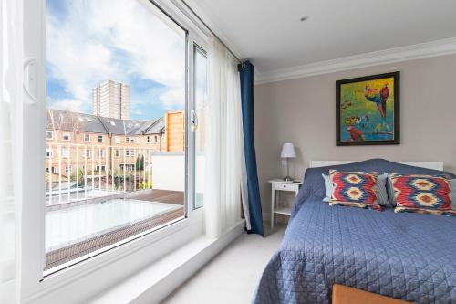 ロンドンにあるGorgeous 5BR home with garden and parking in Batterseaのベッドルーム1室(ベッド1台、大きな窓付)